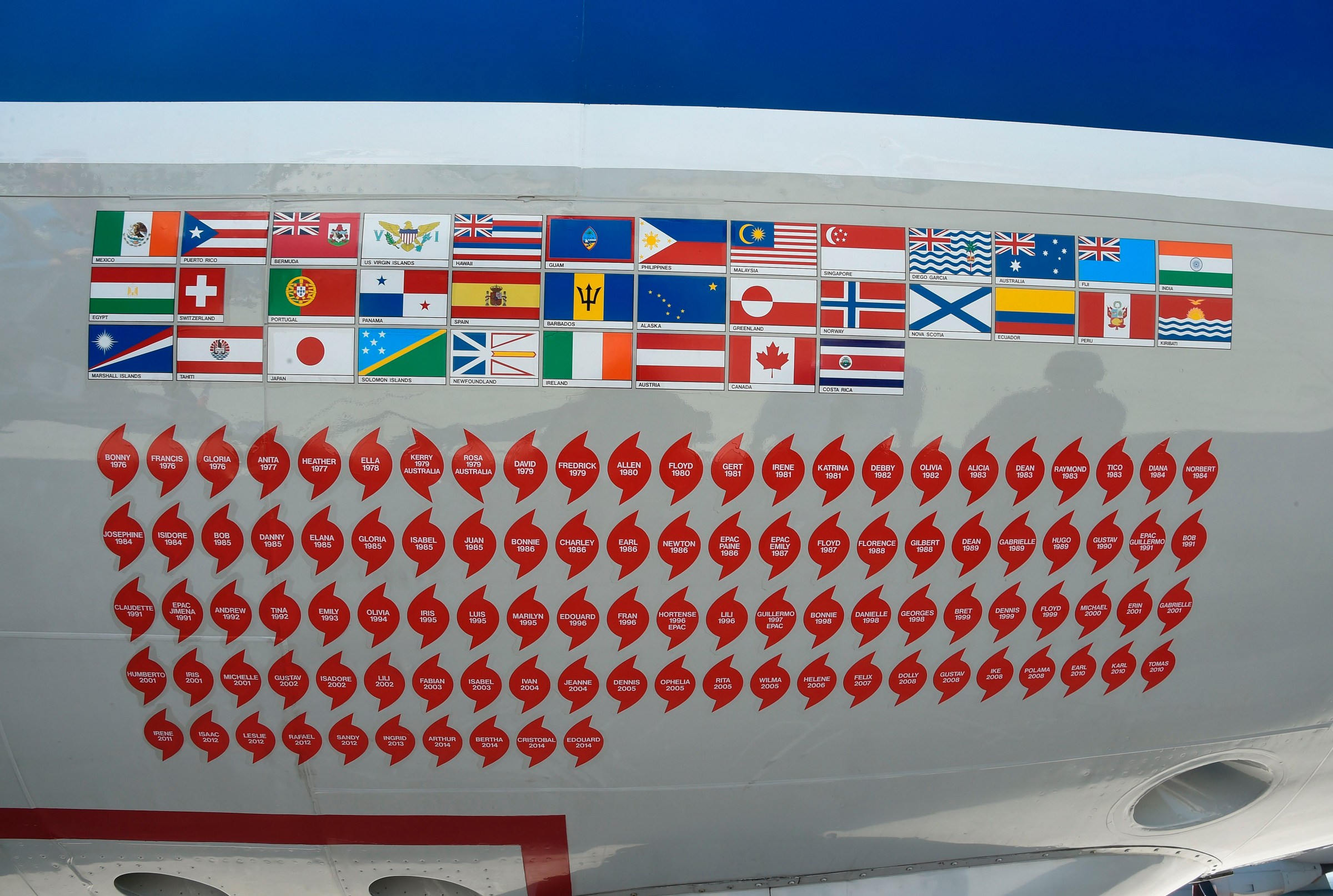 The nose of one of NOAA’s hurricane hunter aircraft displays long rows of stickers, around 100 of them in lines.